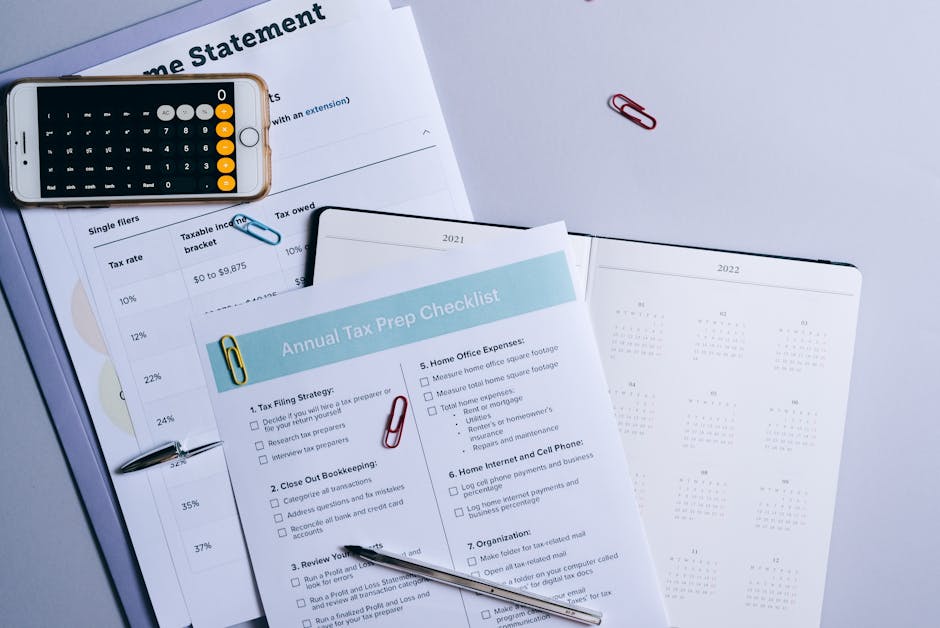 Flat lay of a tax preparation checklist, calculator, and financial documents on a desk.